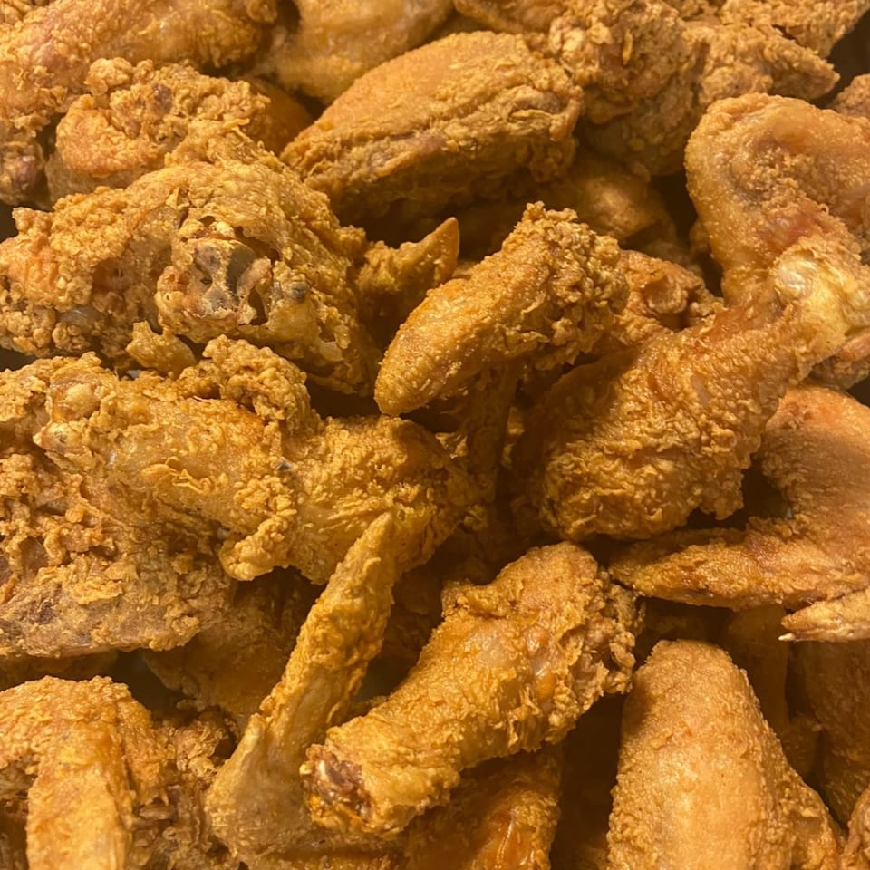 Close-up of a pile of golden-brown, crispy fried chicken pieces from Southern Soul Cafe.