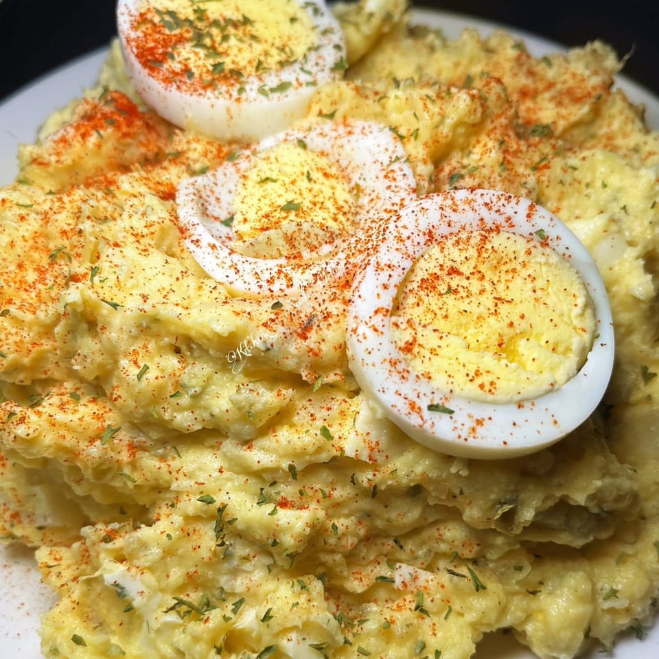 Creamy potato salad from Southern Soul Cafe, garnished with paprika, herbs, and hard-boiled egg slices.
